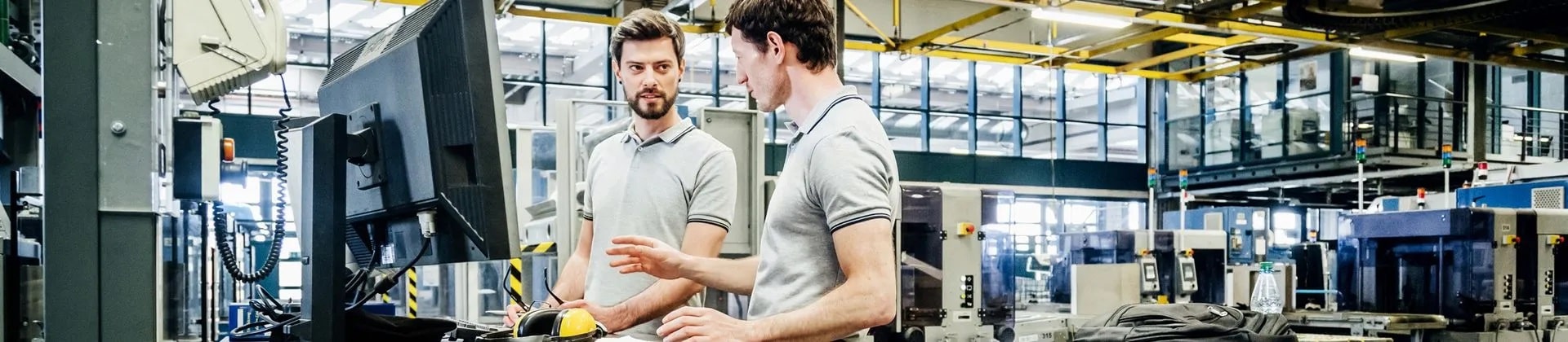 two men talk in an open lab space