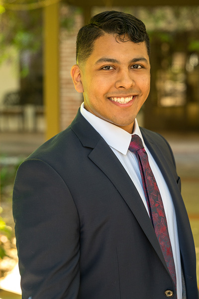 man in a suit smiles at the camera