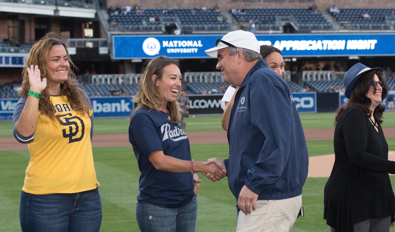 National University President Dr. David Andrews congratulates teachers on the Petco Park field