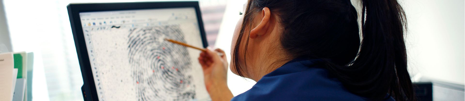 A woman in the Master of Forensic Sciences program looks at an enlarged image of a fingerprint