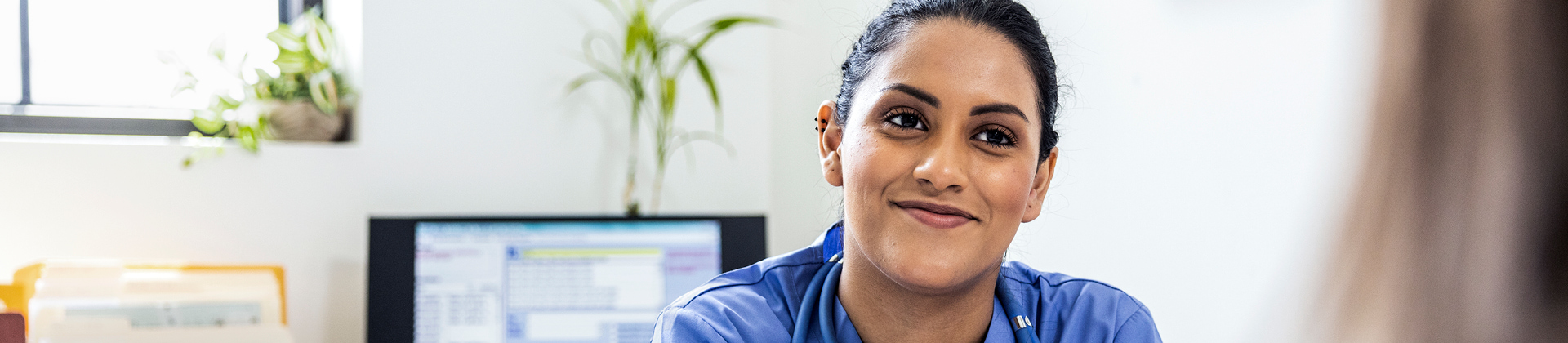 doctor in office sitting at her desk with a patient